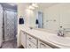 Bright bathroom featuring a double sink vanity, framed mirror, and a shower with a patterned curtain at 1421 Rustic Dr, Longmont, CO 80504