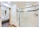 Modern bathroom featuring a walk-in shower with decorative tile and glass door, located off of the main bedroom at 1421 Rustic Dr, Longmont, CO 80504