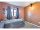 Cozy bedroom showcasing a gray bedspread, window with light curtains, and warm-toned walls at 1421 Rustic Dr, Longmont, CO 80504