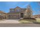 Two-story home with a two car garage, stone accents, tidy lawn, and blossoming tree at 1421 Rustic Dr, Longmont, CO 80504