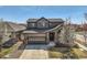 Charming two-story home showcasing mature landscaping, a well-manicured lawn, and a neutral-tone exterior at 1421 Rustic Dr, Longmont, CO 80504