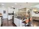 Spacious kitchen with granite counters, stainless appliances, an island with barstool seating, and stylish wood accent wall at 1421 Rustic Dr, Longmont, CO 80504