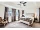 Bright primary bedroom featuring a tray ceiling, large windows, neutral carpeting and a comfortable bed at 1421 Rustic Dr, Longmont, CO 80504
