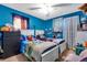 Bright bedroom with dual beds, blue walls, playful decor, and plenty of natural light at 5519 Tucson St, Denver, CO 80239