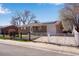 Brick ranch-style home with gated driveway, solar panels, and front yard at 5519 Tucson St, Denver, CO 80239