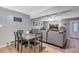 View of an open concept living and dining area, featuring a comfortable sectional and dining table at 5519 Tucson St, Denver, CO 80239