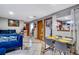 Bright living room with blue sofa, adjacent to glass top dining table, seamlessly flowing into other spaces at 5519 Tucson St, Denver, CO 80239