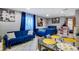 Open-concept living room with plush blue couches, bright decor, and tiled floors for easy maintenance at 5519 Tucson St, Denver, CO 80239