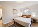Bright bedroom features hardwood floors, neutral walls, and a comfortable bed with soft lighting at 2555 Hudson St, Denver, CO 80207