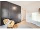 Charming bedroom featuring dark gray wardrobe, hardwood floors, and a comfortable chair and pillows at 2555 Hudson St, Denver, CO 80207