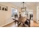 Elegant dining room with a wooden table, modern light fixture, and view of the kitchen at 2555 Hudson St, Denver, CO 80207