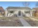 Charming home with gray brick, black shutters, metal railings, and a walkway leading to the front door at 2555 Hudson St, Denver, CO 80207