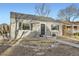 Charming home with gray brick, black shutters, metal railings, and a walkway leading to the front door at 2555 Hudson St, Denver, CO 80207