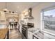Bright kitchen featuring stainless appliances, white cabinets, gray countertop, and view to dining area at 2555 Hudson St, Denver, CO 80207