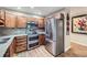 Modern kitchen featuring stainless steel appliances, wood cabinets, and tile backsplash at 3022 S Wheeling S Way # 410, Aurora, CO 80014