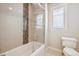 Bright bathroom with a glass-enclosed tub and shower, complemented by a window with plantation shutters at 34 Sommerset Cir, Englewood, CO 80111
