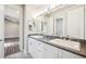 Bathroom with double sinks, white cabinets, granite countertops, tile backsplash, and mirrors at 34 Sommerset Cir, Englewood, CO 80111