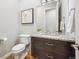 Stylish half-bathroom boasts granite countertop, framed vanity mirror and dark wood cabinets at 34 Sommerset Cir, Englewood, CO 80111