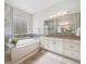 Bright bathroom features a soaking tub with a glass block window for added natural light and privacy at 34 Sommerset Cir, Englewood, CO 80111