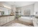 Spa-like bathroom with double vanities, soaking tub, and glass-enclosed shower at 34 Sommerset Cir, Englewood, CO 80111