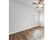 Light-filled bedroom features wood floors, ceiling fan, and large window with plantation shutters at 34 Sommerset Cir, Englewood, CO 80111