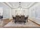 Bright dining room featuring a stylish chandelier, tray ceiling, and shuttered windows at 34 Sommerset Cir, Englewood, CO 80111