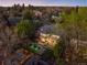 Aerial view of a home with a well-lit patio, swimming pool and lush trees at dusk at 19 S Eudora St, Denver, CO 80246