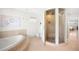 Bright bathroom with a soaking tub and a unique curved glass enclosed shower at 19 S Eudora St, Denver, CO 80246