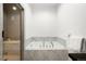 Modern bathroom showcasing a marble-clad tub, glass shower, and tiled floor at 19 S Eudora St, Denver, CO 80246