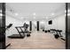 Basement exercise room with a mirrored wall, treadmills, a TV, weights, and hardwood flooring at 19 S Eudora St, Denver, CO 80246