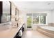 Luxurious main bathroom with dual vanities, soaking tub, and a private balcony at 19 S Eudora St, Denver, CO 80246