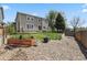 Landscaped backyard with grass, planting boxes, and two-story home in background at 4713 S Ireland St, Aurora, CO 80015