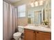 Well-lit bathroom features a wooden vanity and shower with curtain at 4713 S Ireland St, Aurora, CO 80015