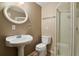 Bathroom featuring a pedestal sink, toilet, and shower with a glass door at 4713 S Ireland St, Aurora, CO 80015