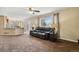 Comfortable living room with a large window, neutral carpet, and an adjacent kitchen area at 4713 S Ireland St, Aurora, CO 80015