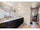 Double vanity bathroom with granite countertops and large mirror at 9066 Sandpiper Dr, Frederick, CO 80504