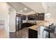 Modern kitchen with dark wood cabinets, granite countertops, and stainless steel appliances at 9066 Sandpiper Dr, Frederick, CO 80504