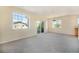 Bright, open living room featuring large windows, balcony access, and neutral carpeting at 5255 Memphis St # 315, Denver, CO 80239