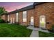 Charming brick townhomes with well-manicured lawns and inviting front entrances with a twilight sky background at 4445 S Lowell Blvd, Denver, CO 80236