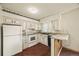 Bright kitchen with white appliances, contrasting countertops, and ample cabinet space at 4445 S Lowell Blvd, Denver, CO 80236