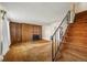 Spacious living room featuring wood paneling, a fireplace, and staircase at 4445 S Lowell Blvd, Denver, CO 80236