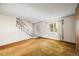 Bright living room with staircase, large window, and neutral carpet at 4445 S Lowell Blvd, Denver, CO 80236
