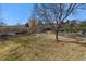 Spacious backyard with grassy area, mature trees, and a fire pit at 8656 Aberdeen Cir, Highlands Ranch, CO 80130