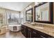 Elegant bathroom with double sinks, granite counters, and a soaking tub at 8656 Aberdeen Cir, Highlands Ranch, CO 80130