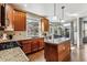 Modern kitchen with wood cabinets, granite counters, and island at 8656 Aberdeen Cir, Highlands Ranch, CO 80130