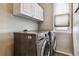 Bright laundry room features modern LG washer and dryer, and ample overhead cabinetry at 8656 Aberdeen Cir, Highlands Ranch, CO 80130