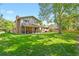 Spacious backyard with lush green lawn, mature trees, and a covered patio with seating at 455 Greenwood, Longmont, CO 80504