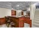 Finished basement bar area, wooden bar with 5 stools, and decorative tin ceiling at 455 Greenwood, Longmont, CO 80504