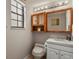 Bright bathroom with a wood trimmed mirror, vanity, white countertops, and a storage shelf above the toilet at 455 Greenwood, Longmont, CO 80504