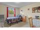Bedroom with a single bed, writing desk, shelving and window with red curtains at 455 Greenwood, Longmont, CO 80504